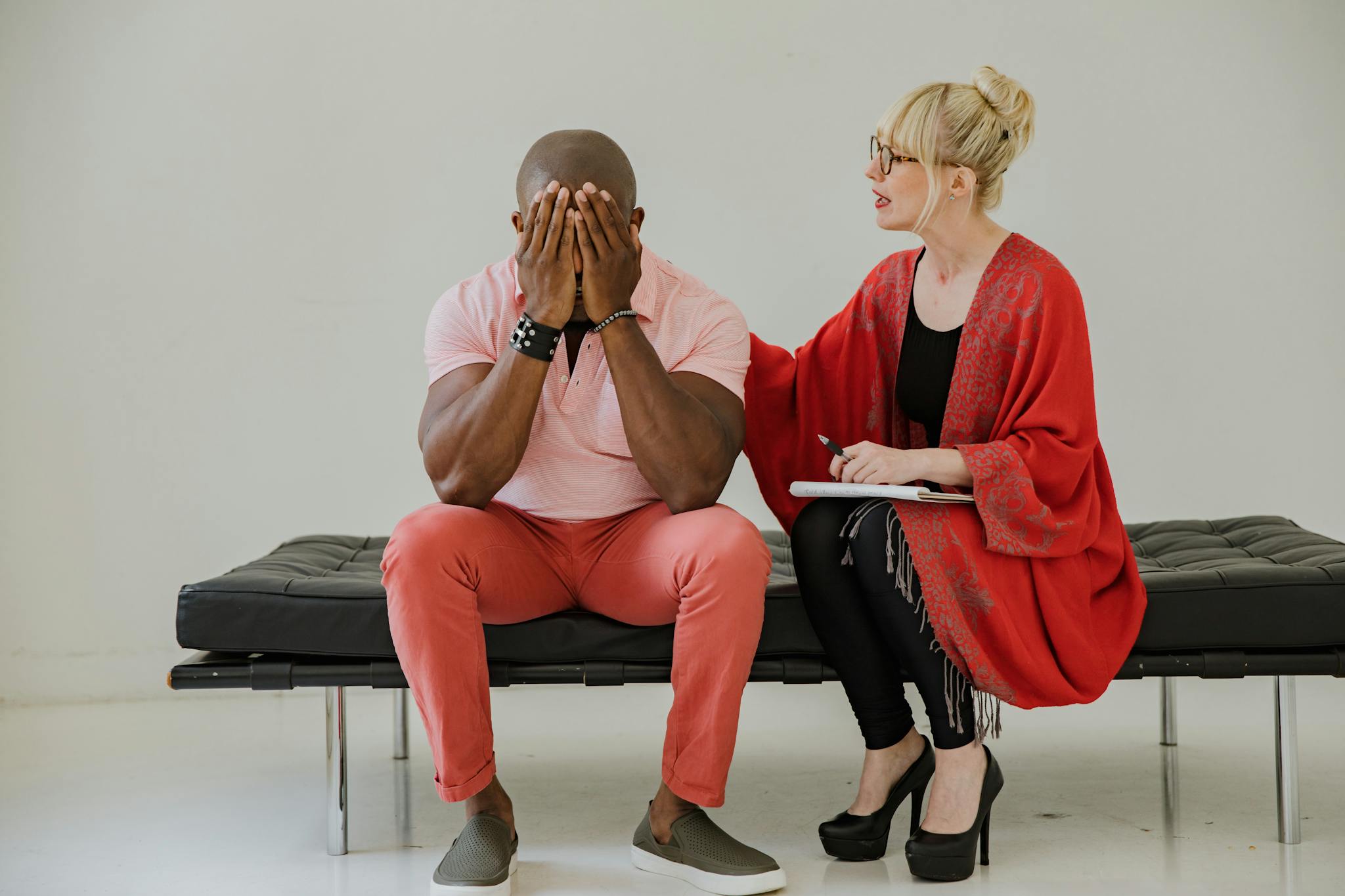 A therapist comforts a distressed man during a counseling session, focusing on mental health.